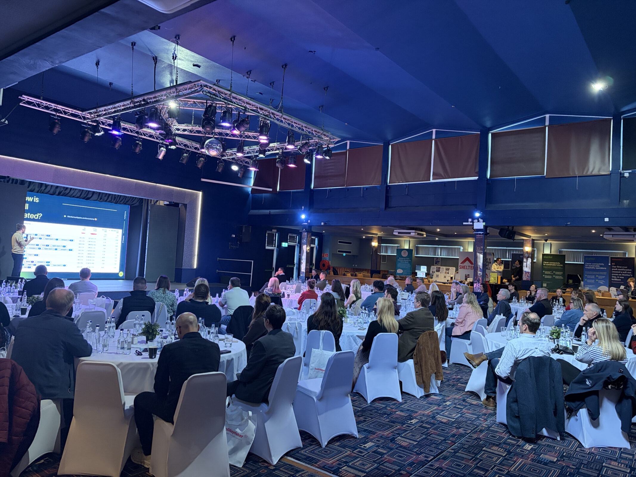Full room of independent hospitality operators at XP Hospitality Dorset, energetic atmosphere with stage lighting