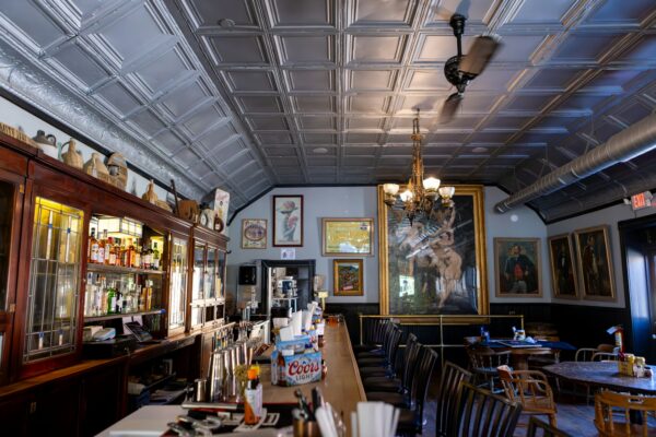 Interior of a bar with artwork and a ceiling fan (photo by Judy Beth Morris on Unsplash)