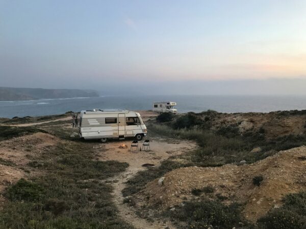 Campervans parked by the coast at sunset (photo by Fabian on Unsplash)