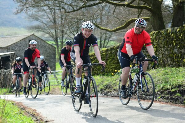 Cyclists smiling and chatting on a country lane