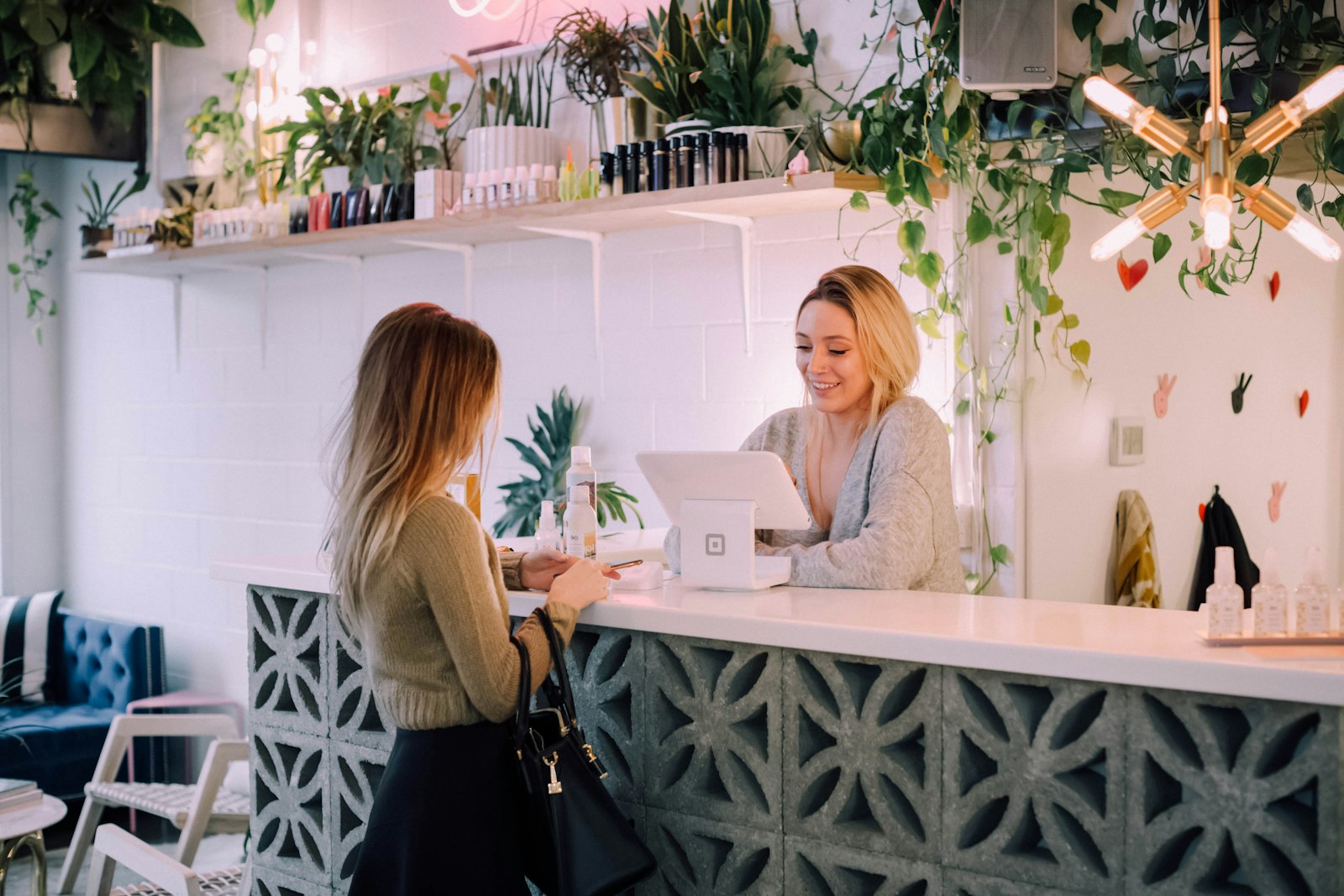 Smiling shop owner welcoming a customer at the counter