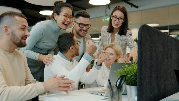 Team celebrating a success with high fives at the office