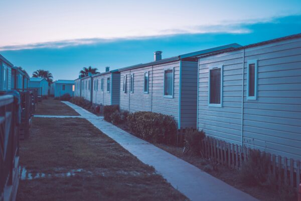 A row of static caravans at dusk under a blue evening sky. Photo by Janek Valdsalu on Unsplash.