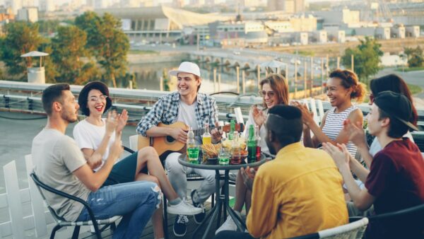 Friends enjoying a rooftop party with music and drinks